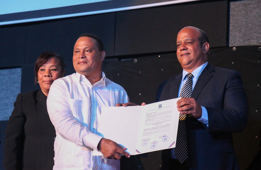 Esteban Beltré, director de operaciones de ege haina, recibe el reconocimiento de manos del alcalde de barahona, Noel Octavio Suberví