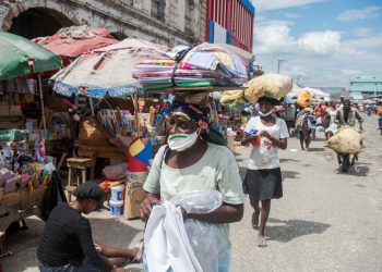 Una mujer con mascarilla camina en un mercado callejero en Puerto Príncipe (Haití). EFE.