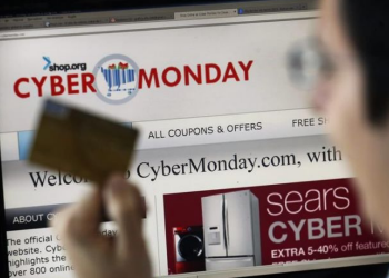 Fotografía de archivo de un hombre con una tarjeta de crédito frente a un ordenador durante el "ciberlunes" con ofertas en diversas tiendas en línea. | Felipe Trueba, EFE.
