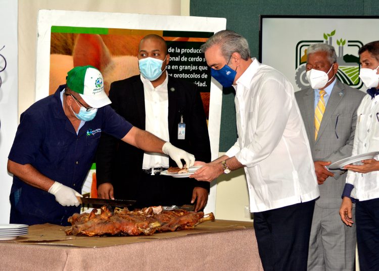 El presidente Luis Abinader comparte con los posicultures en una degustacion de cerdo. (1)