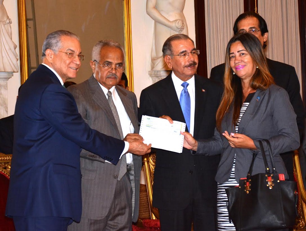 El presidente Danilo Medina entrega un cheque para la iniciativa, que constituye una alianza público-privada entre la JAD y la Dirección de Cooperación Multilateral.