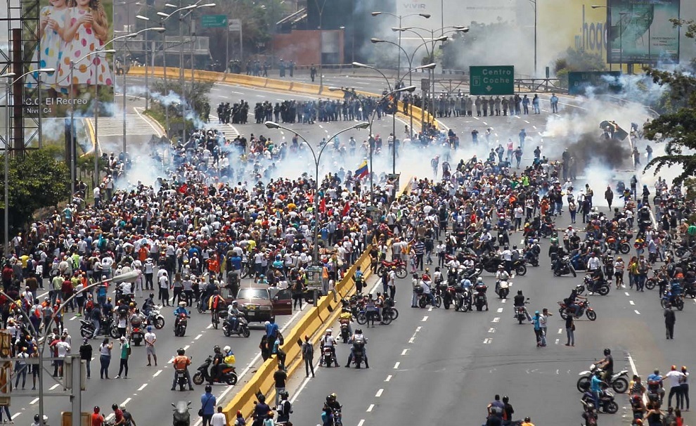 demonstrators clash with riot police while ralling against venezuela's president nicolas maduro's government in caracas