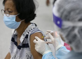 Un médico inyecta una dosis de la vacuna contra el covid-19 a una paciente. | Narong Sangnak, EFE.