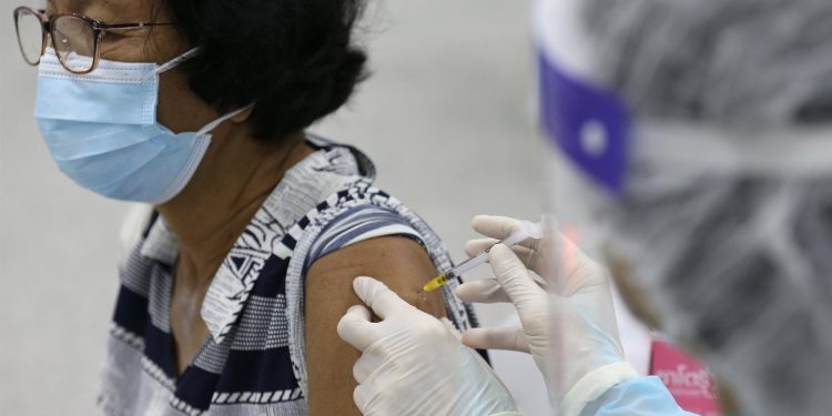 Un médico inyecta una dosis de la vacuna contra el covid-19 a una paciente. | Narong Sangnak, EFE.