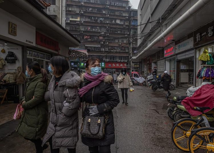 Personas caminan por las calles portando su mascarilla en Wuhan, China. | Roman Pilipey, EFE.