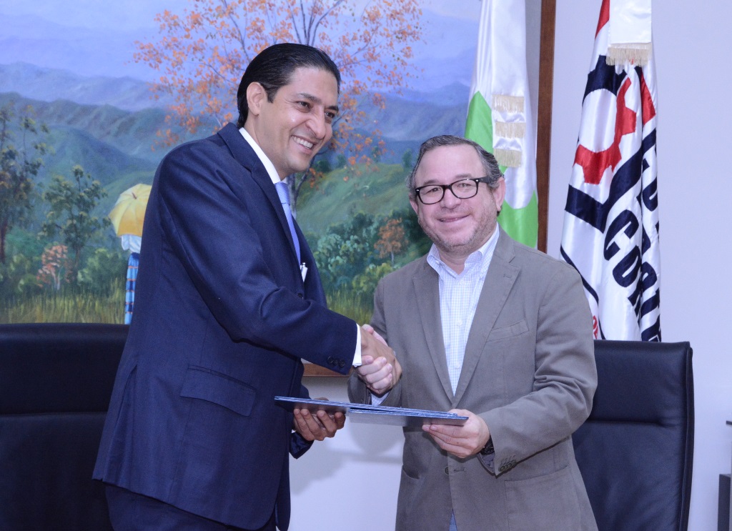 Iván Gatón y Guarocuya Félix luego de la firma del acuerdo de colaboración entre la DGII y la CDC.